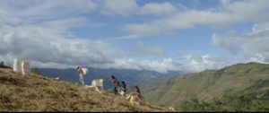 Des paysans en Amérique latine qui marchent dans leur champ le long d’une montagne