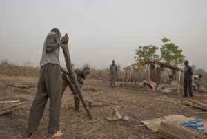 Réfugiés préparent le bois pour une construction de cabane dans le camp de personnes déplacées. Photo : Vlad Karavaev.