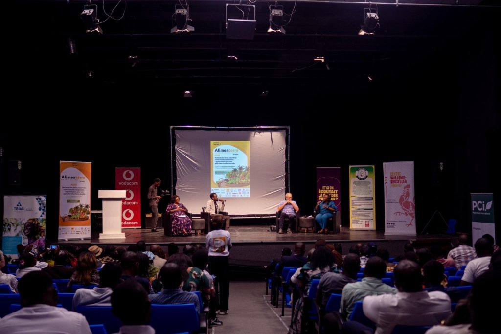 Un salle de projection avec un écran au centre et des spectateurs installés de dos